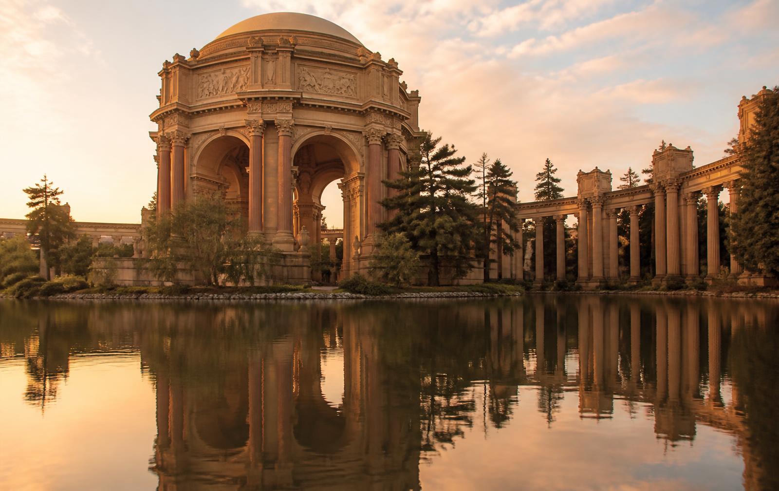 The Palace of Fine Arts rotunda reflected in its lagoon at golden hour